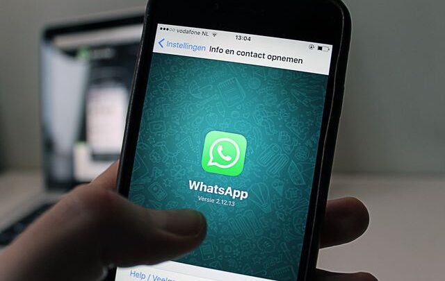 A smartphone displaying the WhatsApp application screen held by a person.